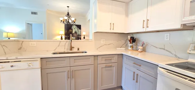 a kitchen with stainless steel appliances granite countertop a sink a stove and cabinets