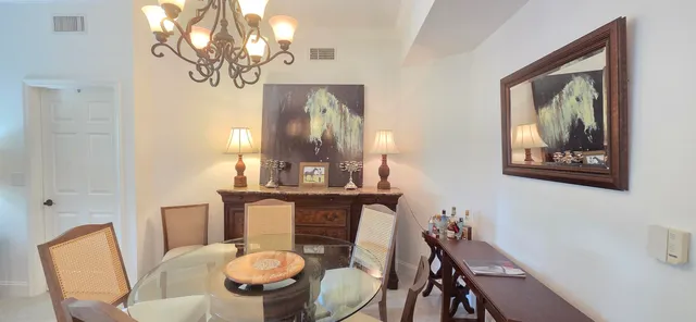 a view of a swimming pool with a lawn chairs under palm trees