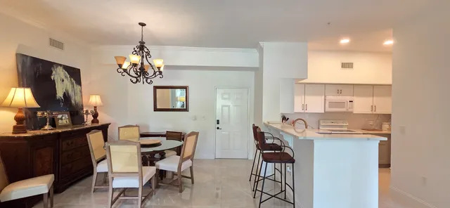 a living room with furniture a chandelier and a dining table