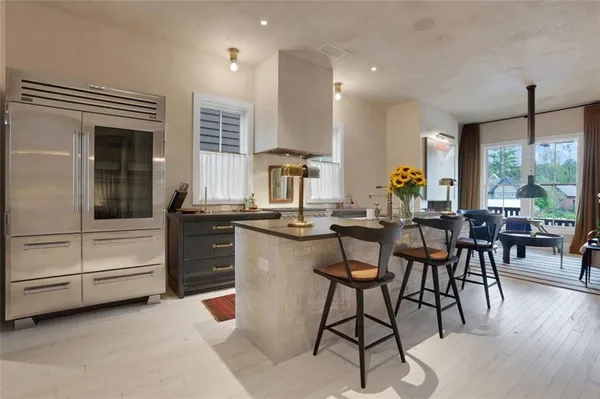 a kitchen with a dining table chairs and large window