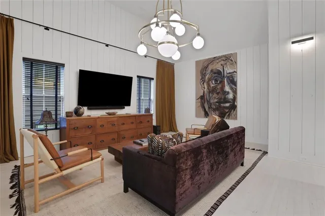 a living room with furniture a flat screen tv and a window