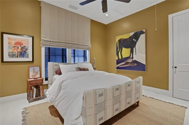 a spacious bedroom with a bed and a painting on the wall