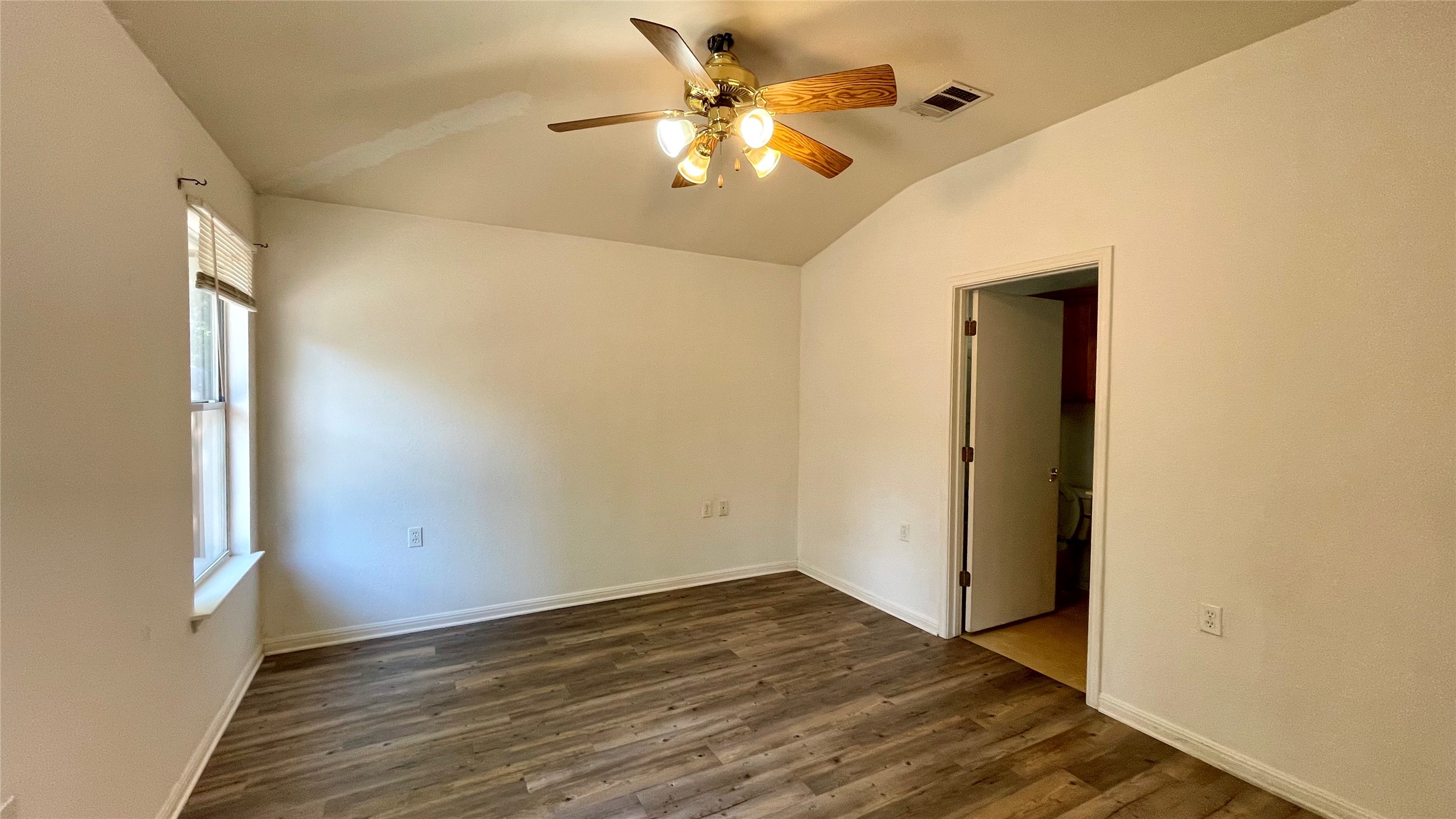 5512 Steven Creek Way Austin, TX 78721 - Photo 11 of 30 Unfurnished bedroom with lofted ceiling, dark wood-style flooring, and ceiling fan