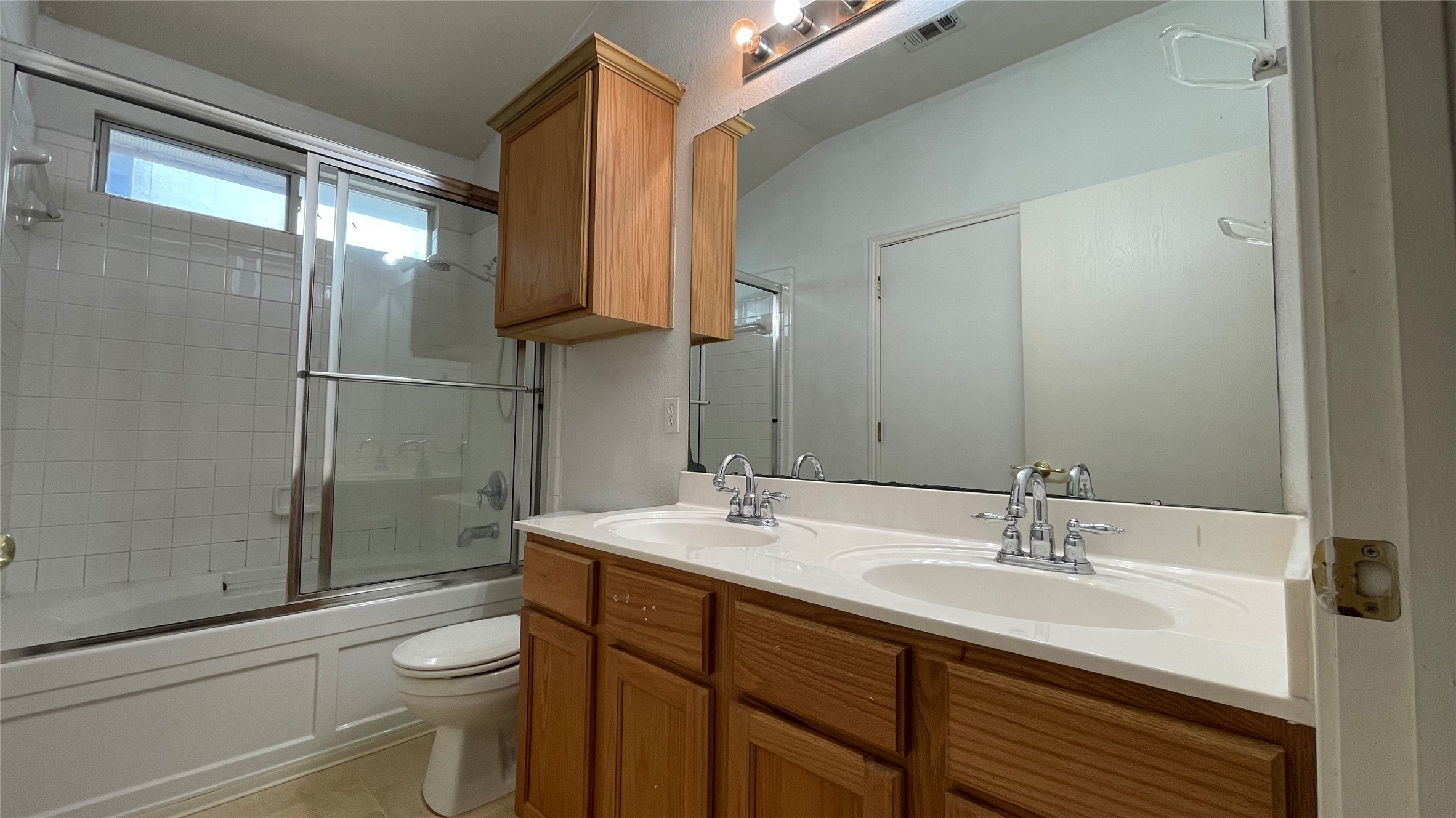 5512 Steven Creek Way Austin, TX 78721 - Photo 13 of 30 Bathroom featuring bath / shower combo with glass door and light tile patterned floors