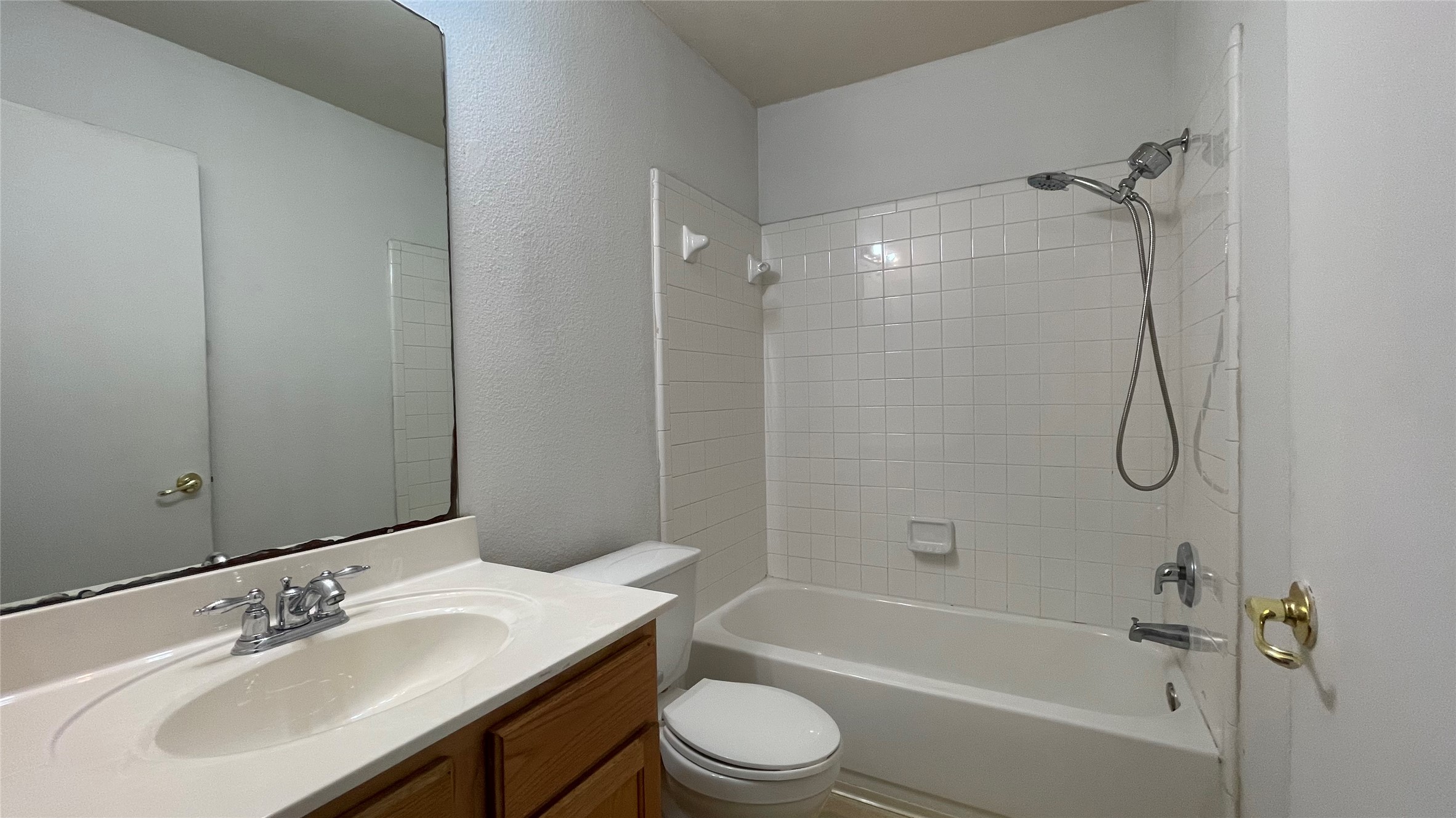 5512 Steven Creek Way Austin, TX 78721 - Photo 15 of 30 Bathroom featuring bathing tub / shower combination, vanity, and a textured wall