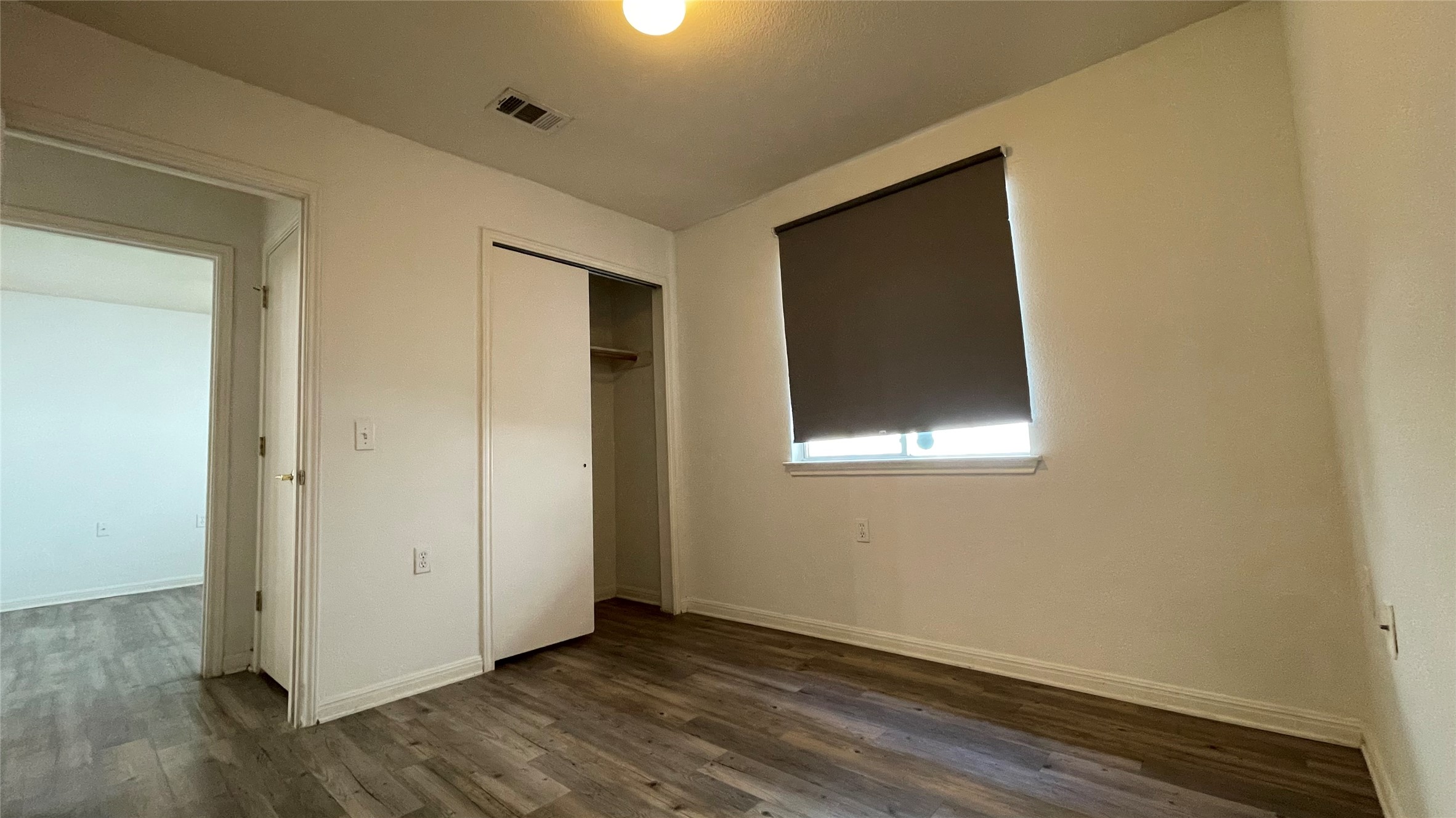 5512 Steven Creek Way Austin, TX 78721 - Photo 16 of 30 Unfurnished bedroom with dark wood-style floors and a closet