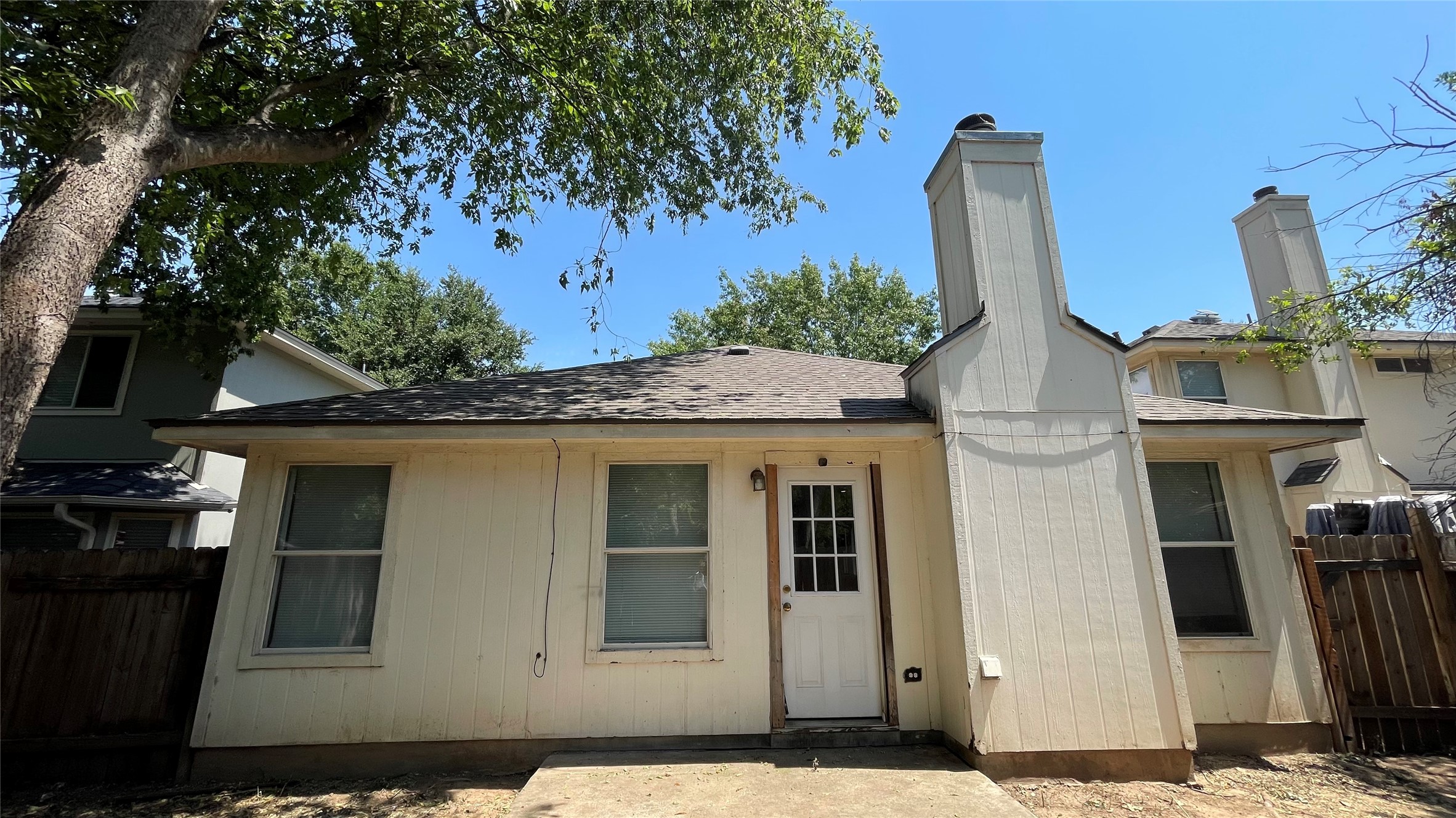 5512 Steven Creek Way Austin, TX 78721 - Photo 20 of 30 Back of property with a shingled roof and a chimney