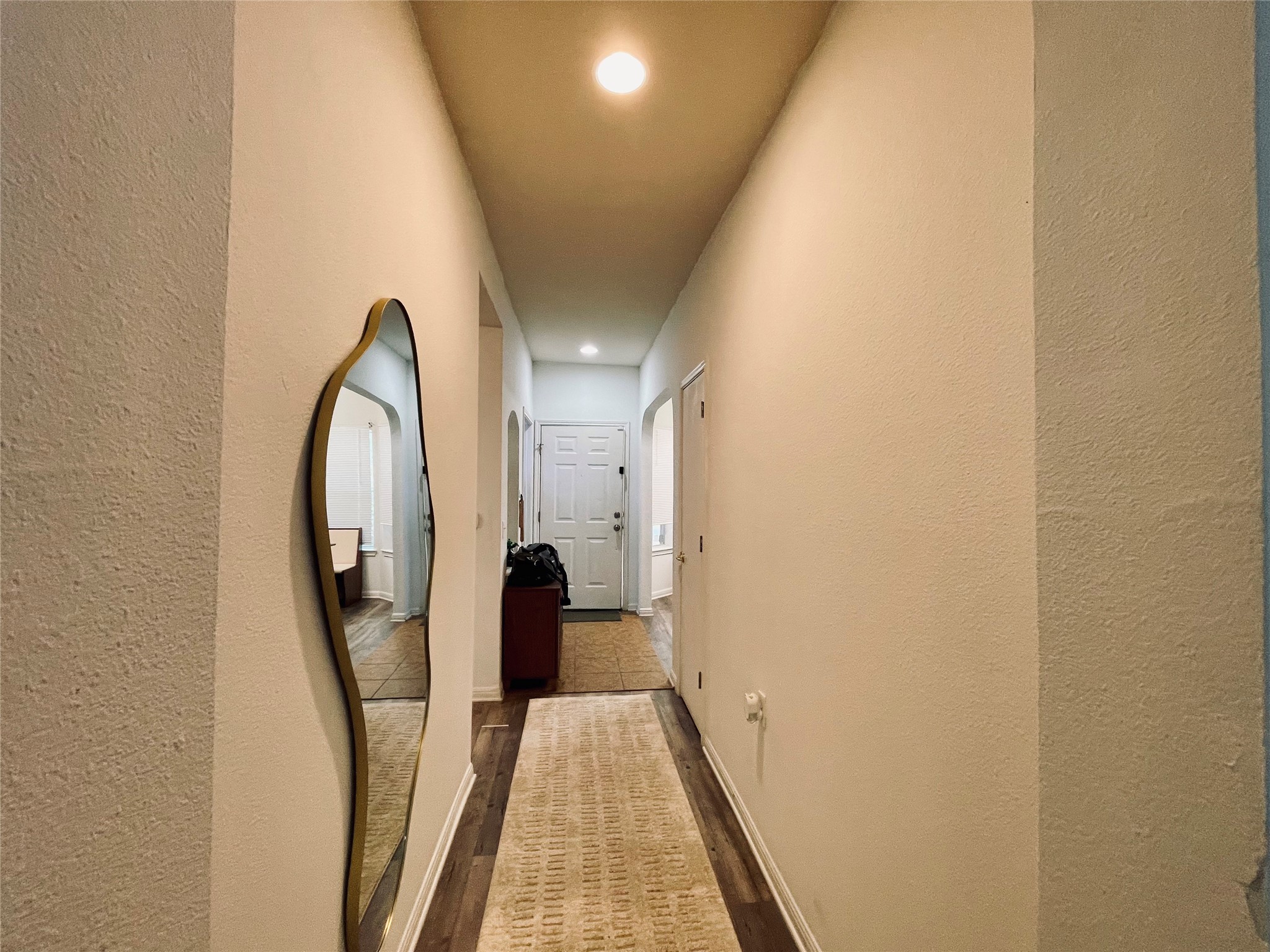 5512 Steven Creek Way Austin, TX 78721 - Photo 26 of 30 Hall with a textured wall, recessed lighting, dark wood-style flooring, and arched walkways