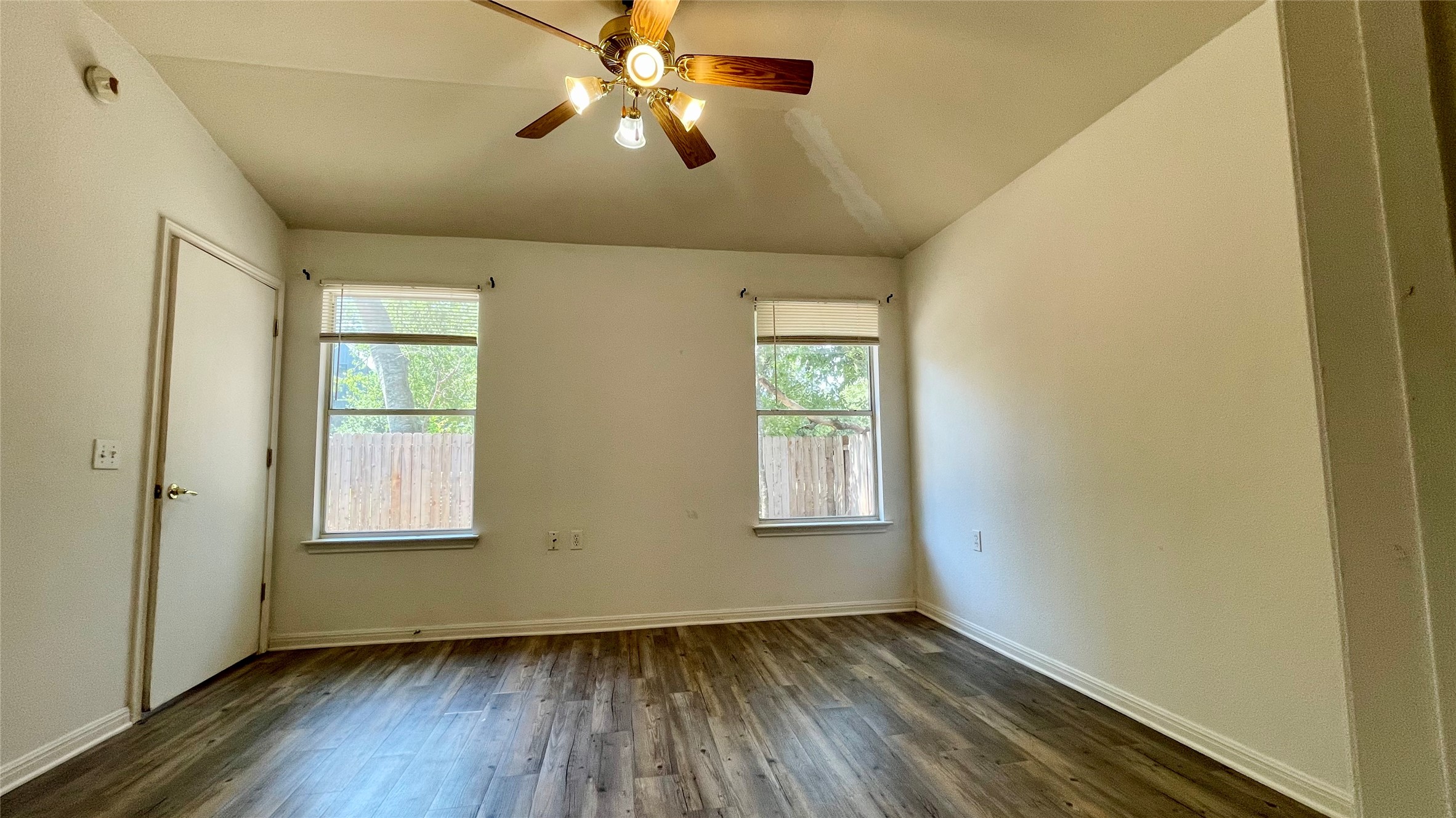 5512 Steven Creek Way Austin, TX 78721 - Photo 3 of 30 Unfurnished room with dark wood finished floors, a ceiling fan, and lofted ceiling