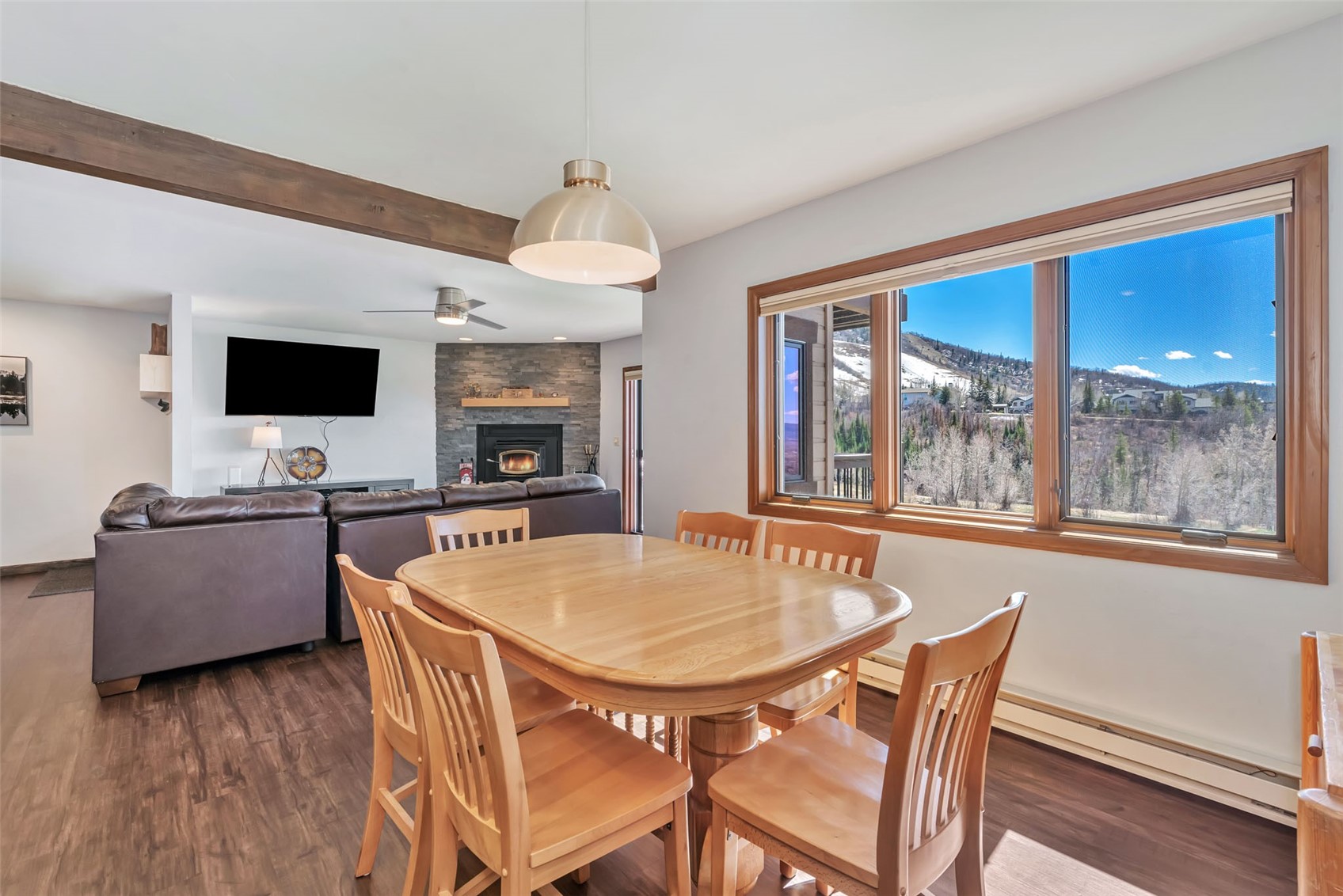 1720 Ranch Road, Unit 309 Steamboat Springs, CO 80487 - Photo 7 of 43 a dining room with furniture a fireplace and wooden floor