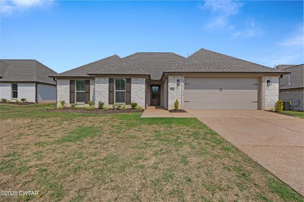 a front view of a house with a yard and garage
