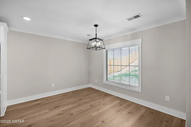 a view of empty room with wooden floor and fireplace