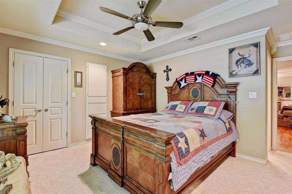 297 Cemetery Road Pottsboro, TX 75076 - Photo 18 of 40 Carpeted bedroom featuring a raised ceiling, ceiling fan, a closet, and crown molding