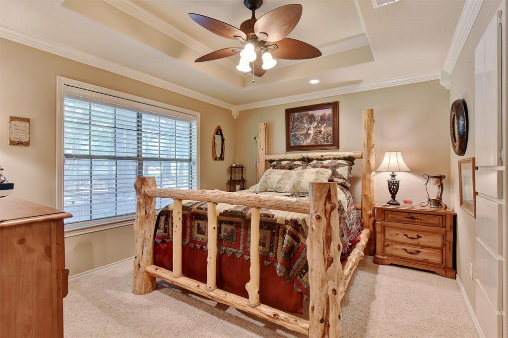 297 Cemetery Road Pottsboro, TX 75076 - Photo 22 of 40 Carpeted bedroom featuring a tray ceiling, ceiling fan, and ornamental molding