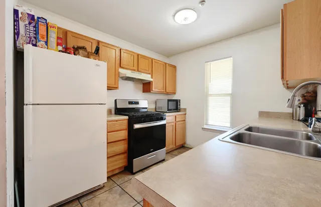 a kitchen with stainless steel appliances granite countertop a sink and a stove