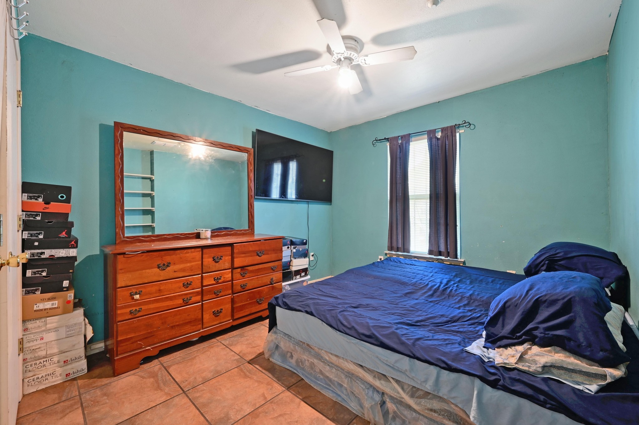 6901 Frontera Trail Austin, TX 78741 - Photo 15 of 21 a bedroom with a bed and a flat tv screen on dresser