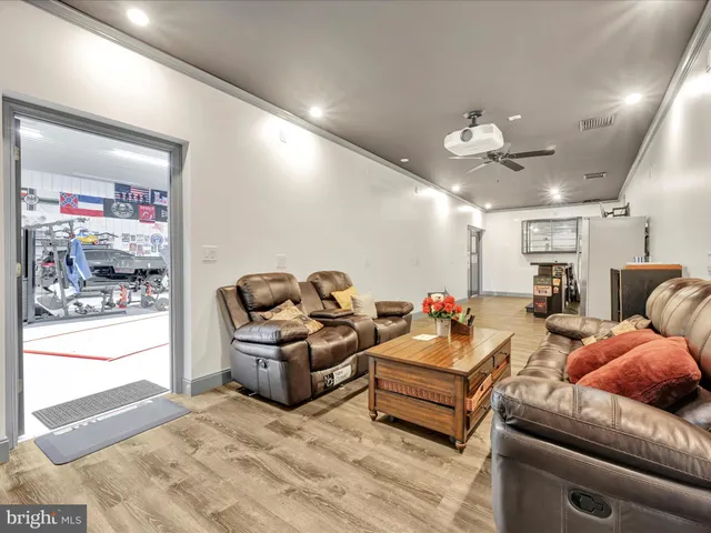 an aerial view of a residential houses with yard and trees in the background