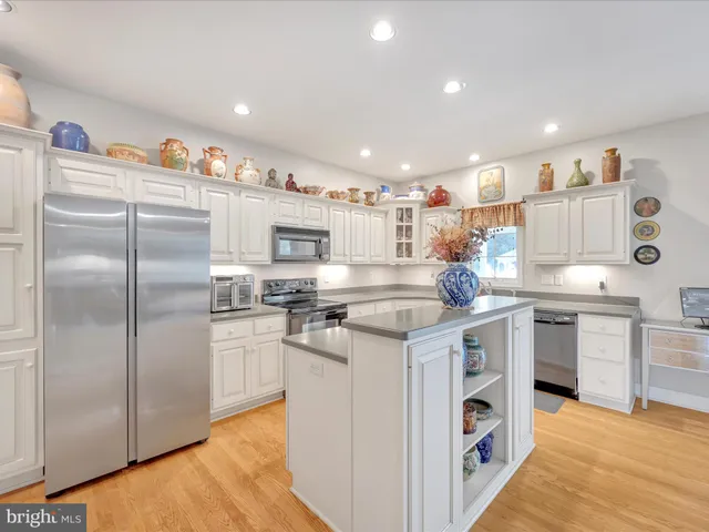 a kitchen with stainless steel appliances granite countertop a refrigerator and a stove top oven