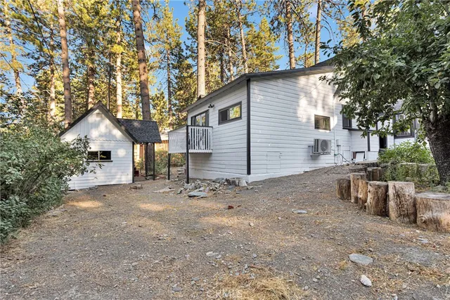 a view of a house with backyard and wooden fence