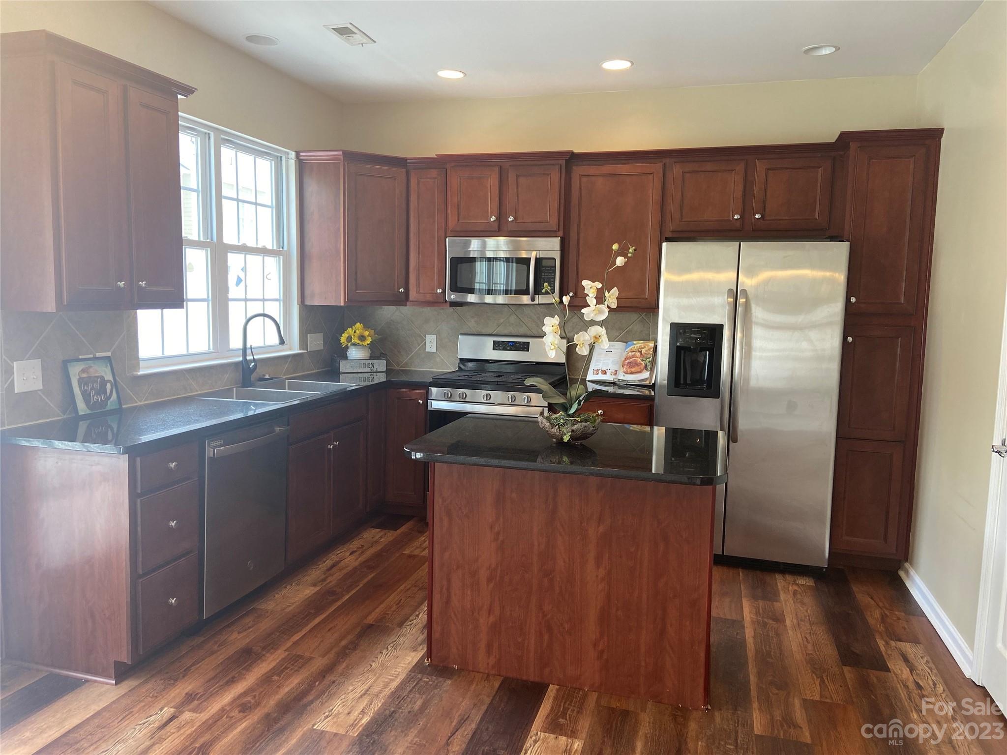 724 Passage Drive Fort Mill, SC 29708 - Photo 5 of 20 a kitchen with wooden cabinets and stainless steel appliances