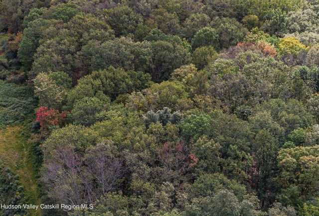 an aerial view of residential house with outdoor space and trees all around