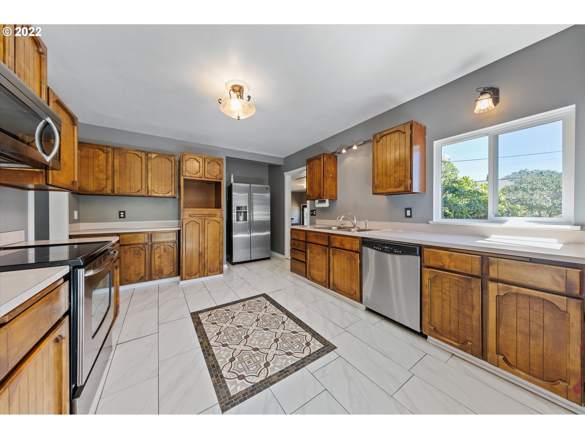 3200 R Street Vancouver, WA 98663 - Photo 10 of 32 a kitchen with stainless steel appliances granite countertop a sink counter space cabinets and a large window