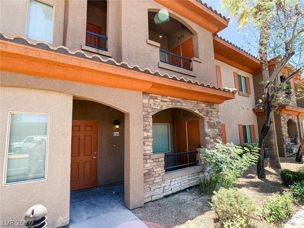 A welcoming front entrance featuring arched doorways and natural stone accents.