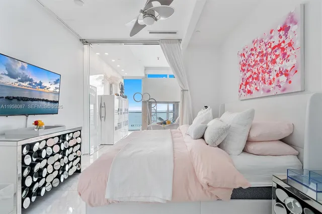 a bedroom with a bed and a lamp on the dresser