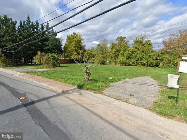 a view of a park with a house in the background