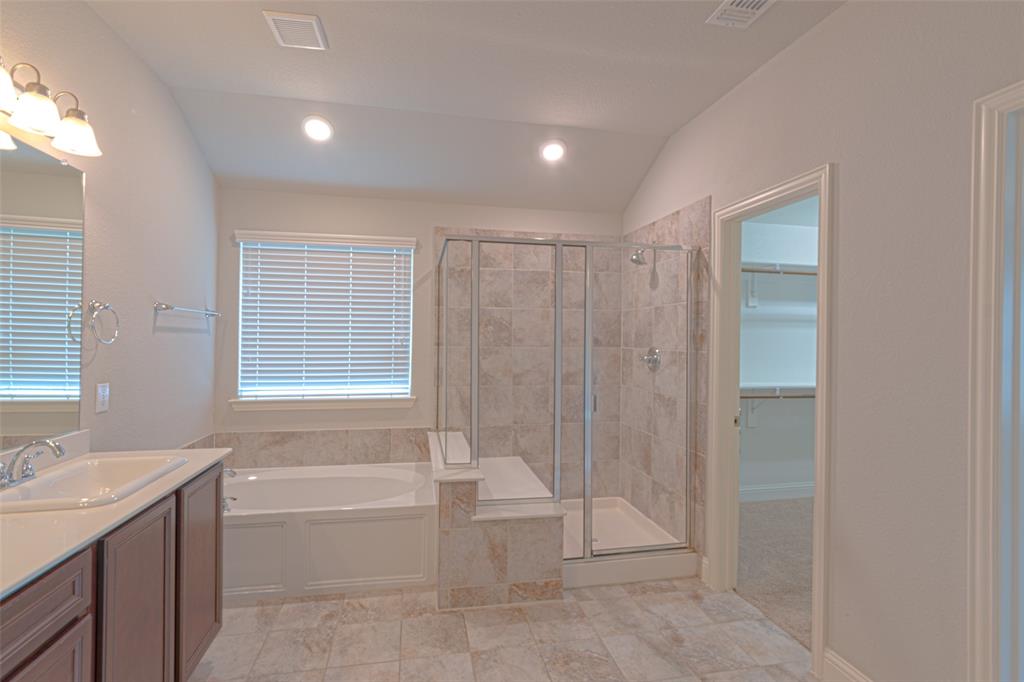 616 England Street Fate, TX 75189 - Photo 19 of 40 Bathroom with vaulted ceiling, a wealth of natural light, shower with separate bathtub, tile flooring, and vanity