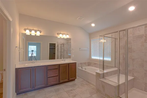 a spacious bathroom with a granite countertop sink a toilet a mirror and bathtub