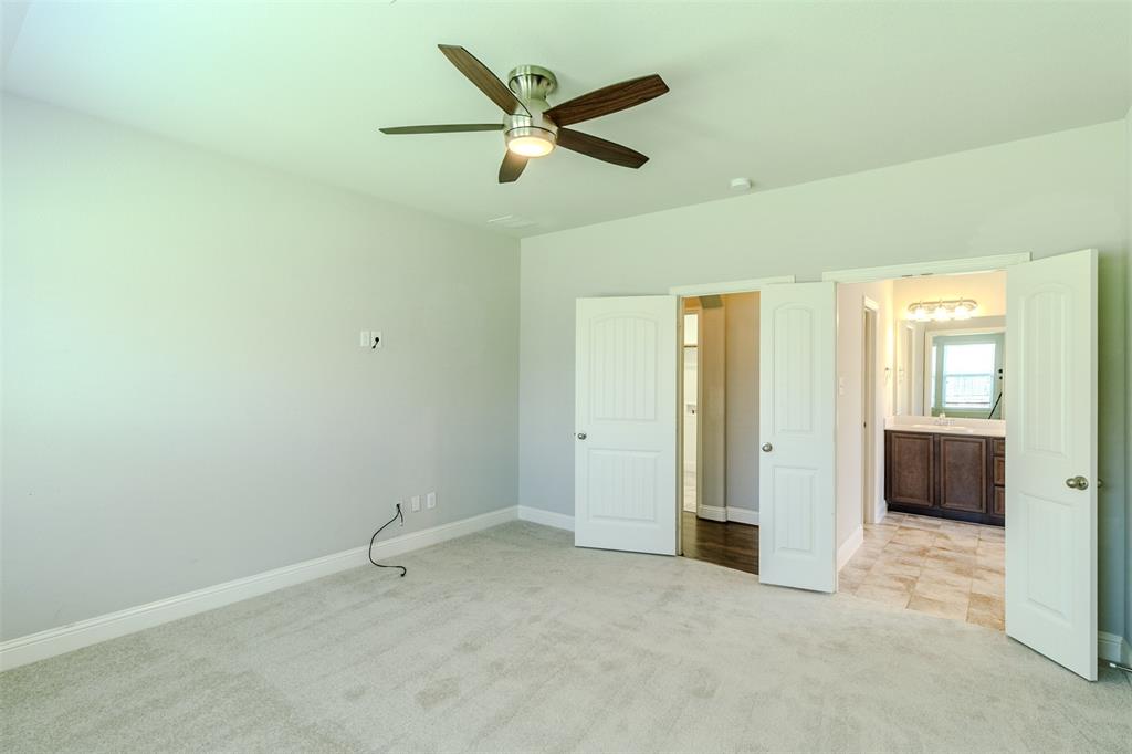 616 England Street Fate, TX 75189 - Photo 24 of 40 Unfurnished master bedroom with light new carpet, ceiling fan, and ensuite bathroom