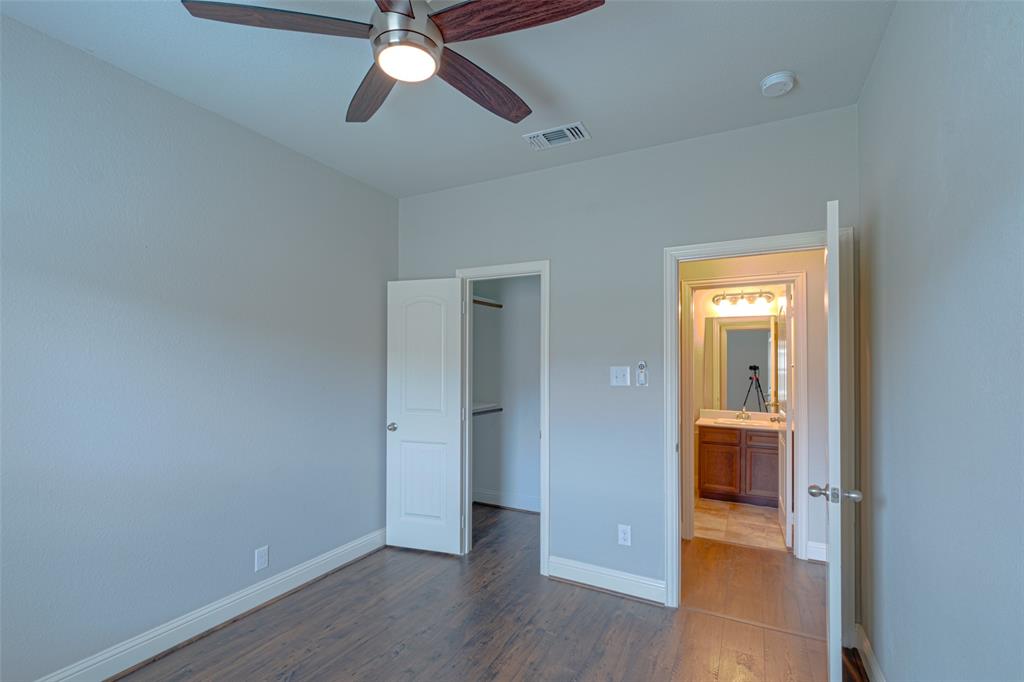 616 England Street Fate, TX 75189 - Photo 29 of 40 Unfurnished bedroom with a spacious closet, dark wood-type flooring, and ceiling fan