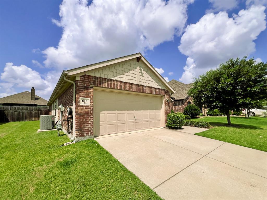 616 England Street Fate, TX 75189 - Photo 36 of 40 View of property exterior with driveway, a garage, and brick siding