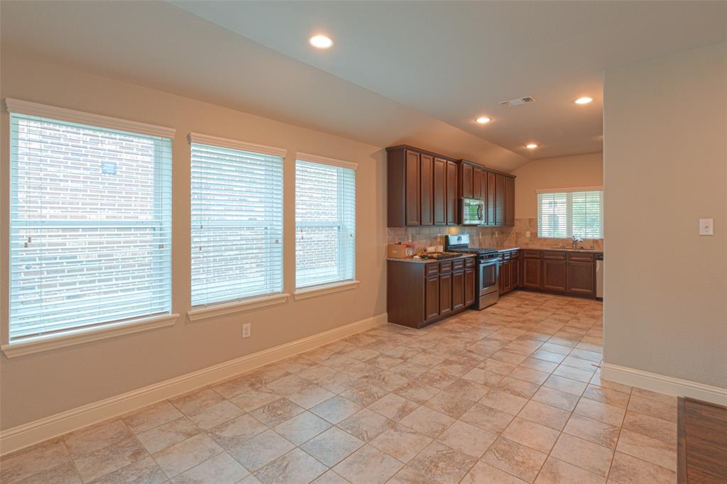 616 England Street Fate, TX 75189 - Photo 4 of 40 Kitchen featuring backsplash, vaulted ceiling, appliances with stainless steel finishes, and light tile floors