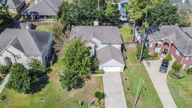 an aerial view of a house with garden space and a swimming pool