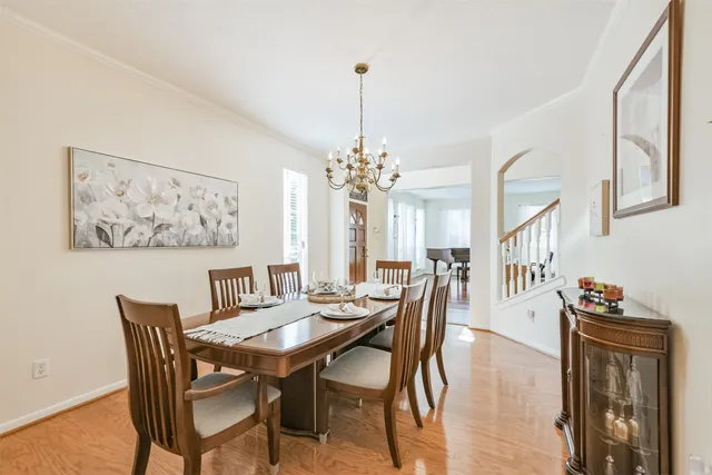 a dining room with furniture a chandelier and wooden floor