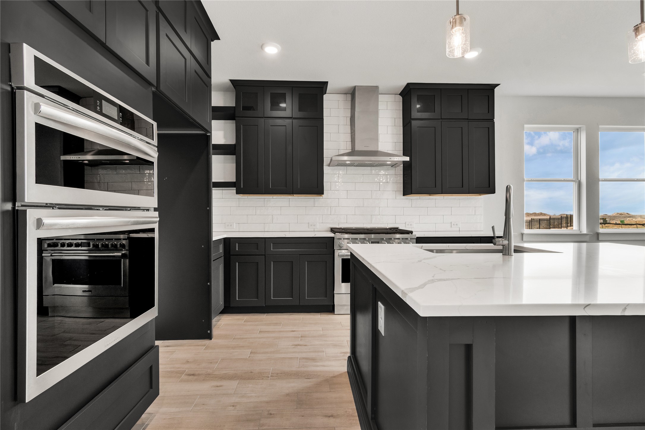 8500 Red Bottle Brush Road Lago Vista, TX 78645 - Photo 11 of 33 Modern kitchen with white quartz countertops and stylish dark cabinetry.