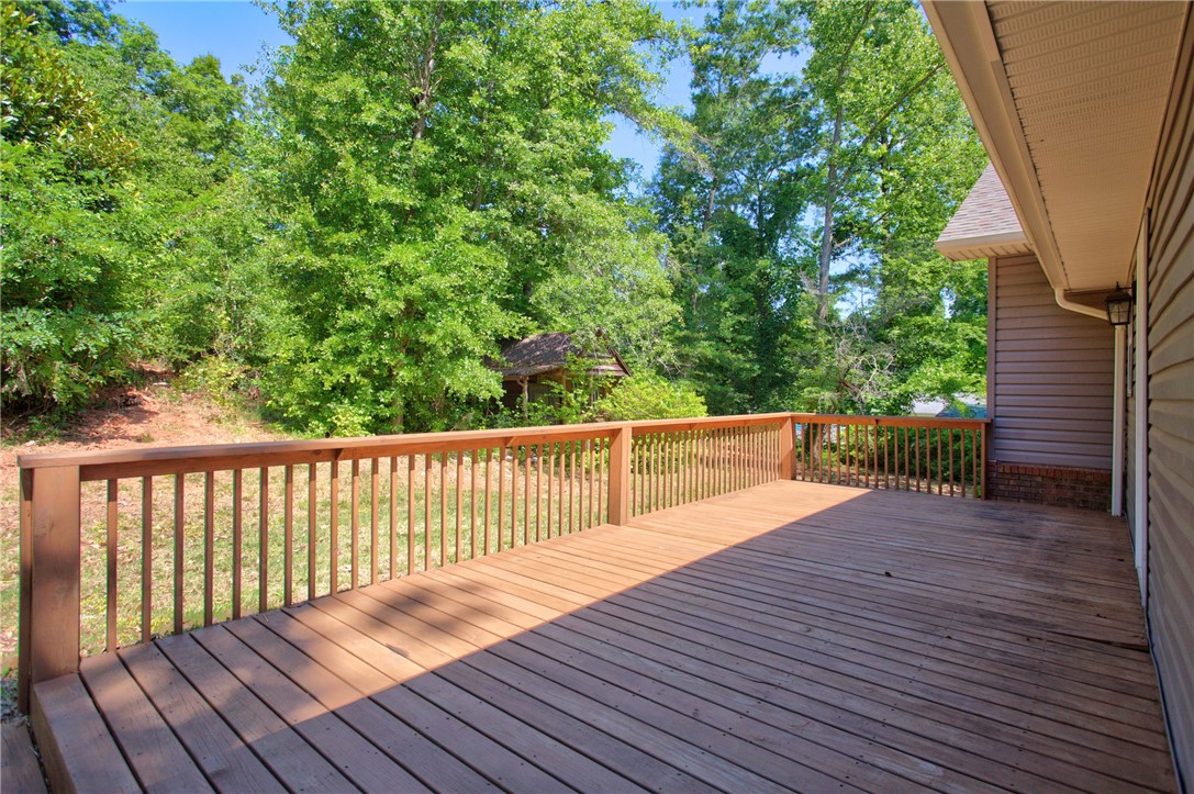 712 Beech Drive Seneca, SC 29678 - Photo 7 of 41 A spacious wooden deck extends into a verdant landscape, perfect for outdoor enjoyment.