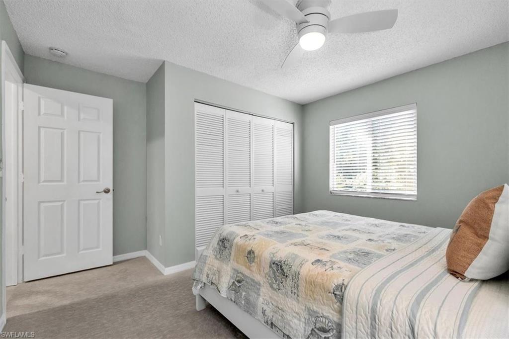 280 Timber Lake Circle, Unit H201 Naples, FL 34104 - Photo 16 of 33 a bedroom with a bed and a chandelier