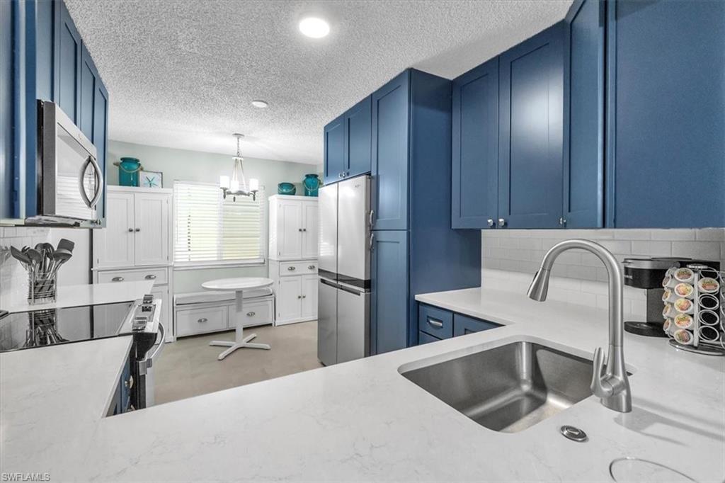 280 Timber Lake Circle, Unit H201 Naples, FL 34104 - Photo 3 of 33 a kitchen with stainless steel appliances granite countertop a sink refrigerator and cabinets