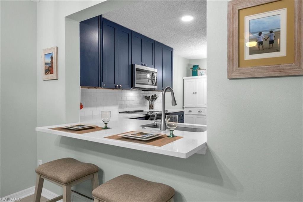 280 Timber Lake Circle, Unit H201 Naples, FL 34104 - Photo 4 of 33 a kitchen with a sink cabinets and wooden floor