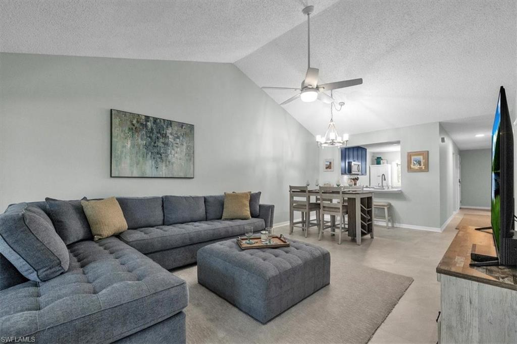 280 Timber Lake Circle, Unit H201 Naples, FL 34104 - Photo 6 of 33 a living room with furniture a dining table and a fireplace