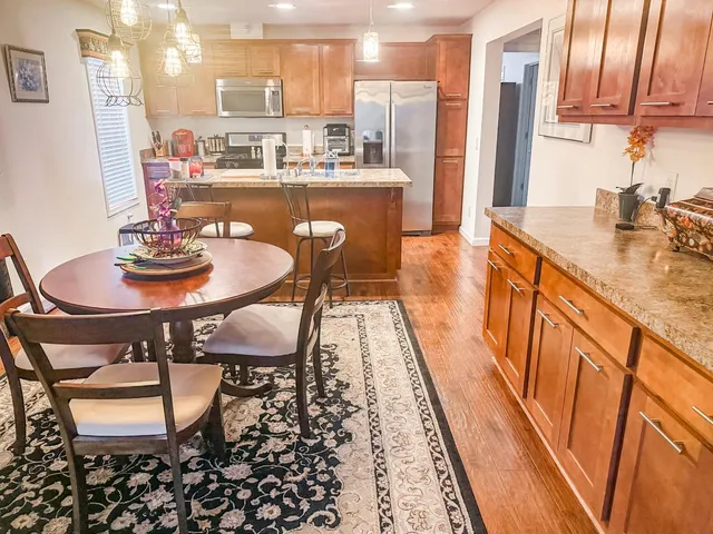 a dining table with chairs and kitchen view