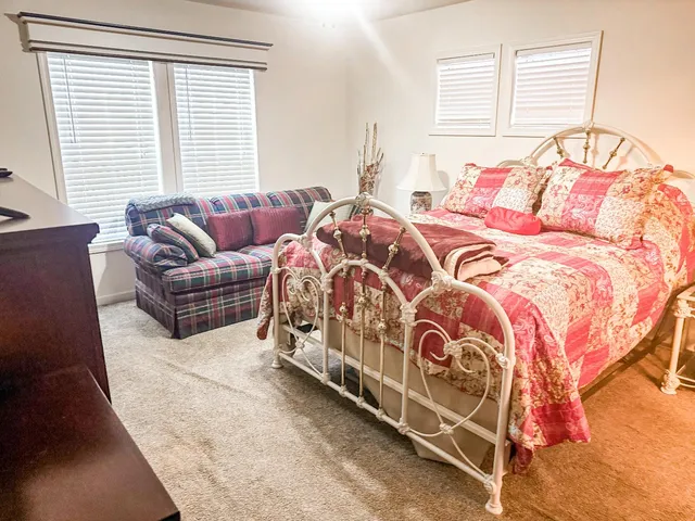 a bedroom with a bed couch and window