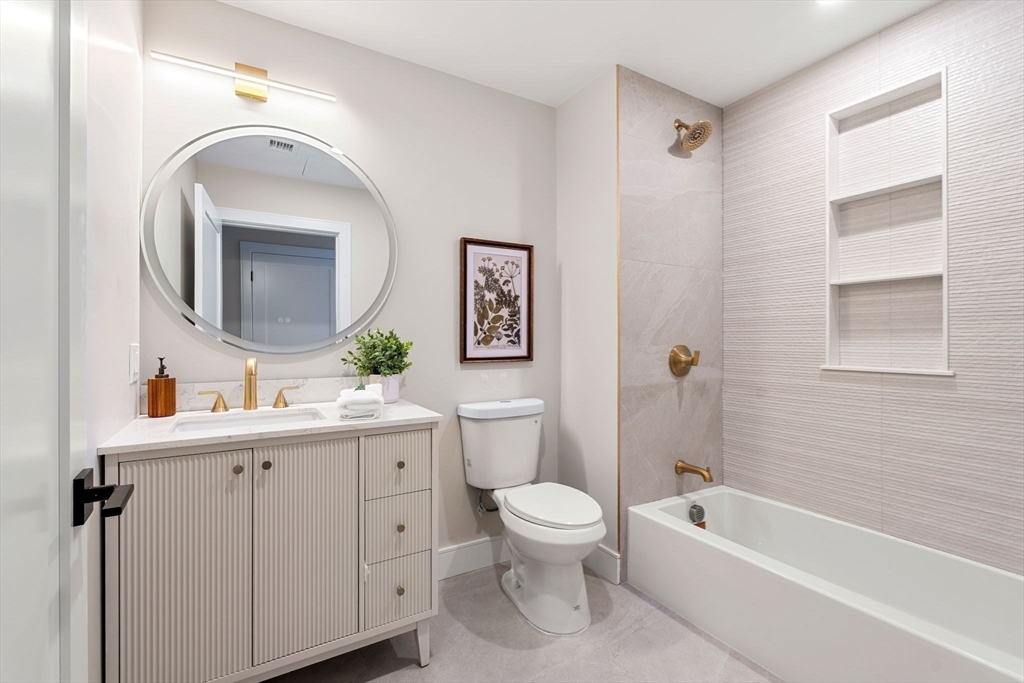 27 Guild Street, Unit 301 Boston, MA 02119 - Photo 22 of 29 a spacious bathroom with a toilet sink and mirror