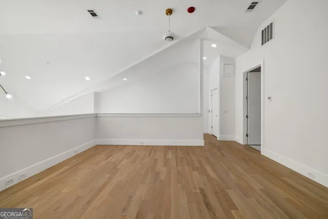 a view of an empty room with wooden floor