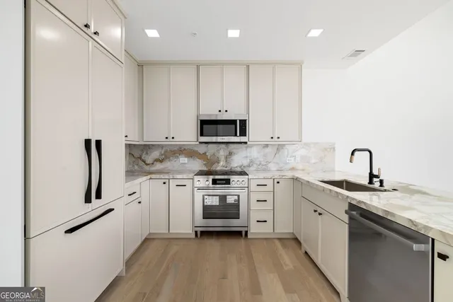 a kitchen with granite countertop white cabinets and white appliances