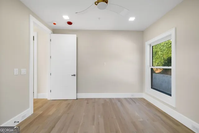 an empty room with wooden floor and windows