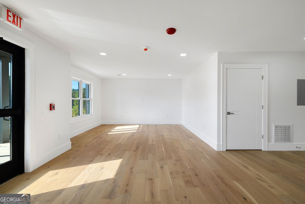 1281 East Main Street Blue Ridge, GA 30513 - Photo 7 of 19 an empty room with wooden floor and windows